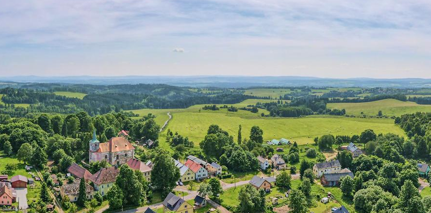 Beautiful landscape of Ovesné Kladruby village in Czech Republic, rolling green hills, flower fields in the foreground, soft morning light, farmhouse in distance, hyper-realistic, 16:10